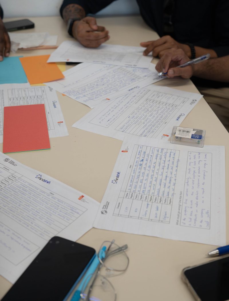 Une équipe diverse travaillant ensemble, examinant des documents et prenant des notes lors d'une réunion collaborative.