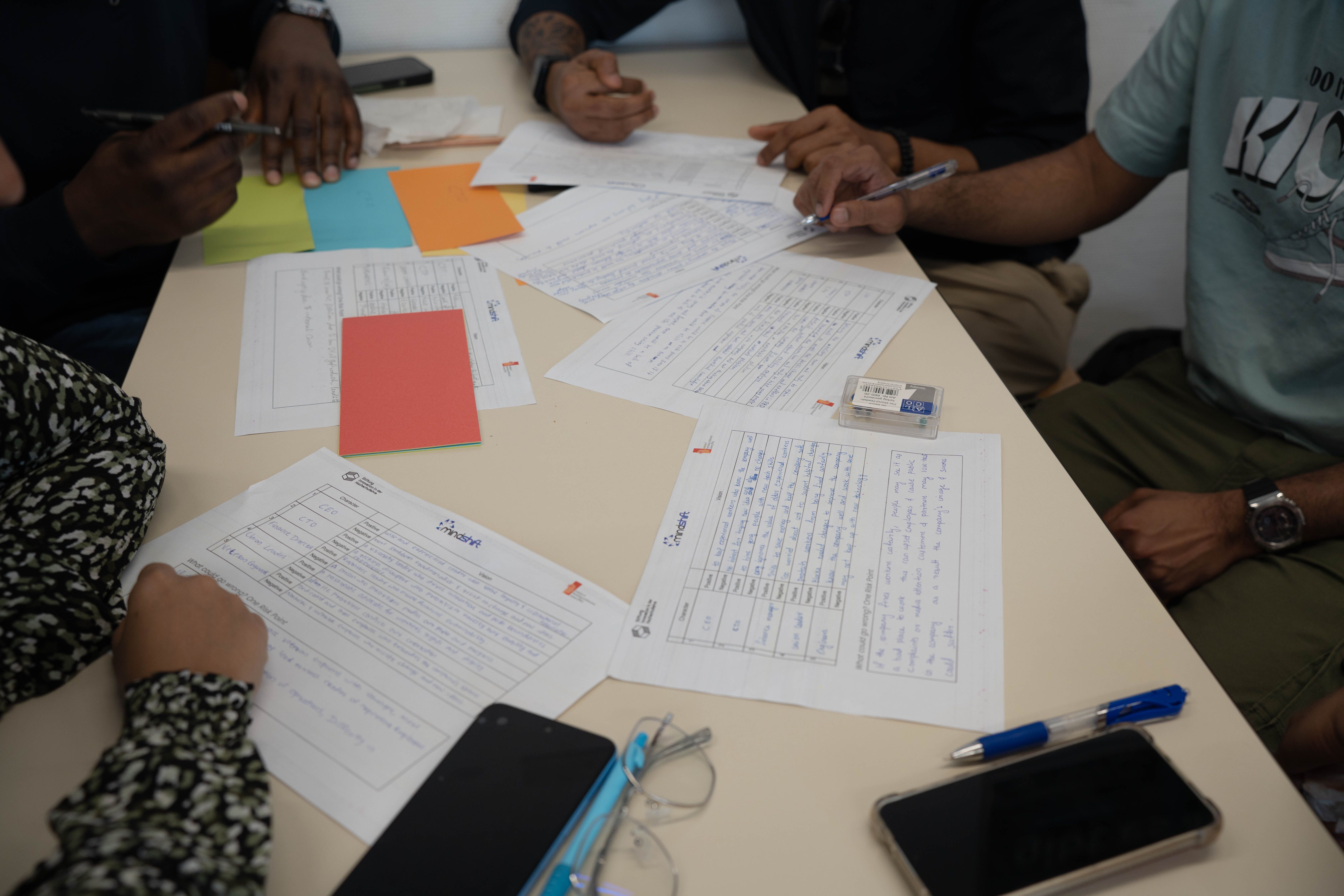 Une équipe diverse travaillant ensemble, examinant des documents et prenant des notes lors d'une réunion collaborative.